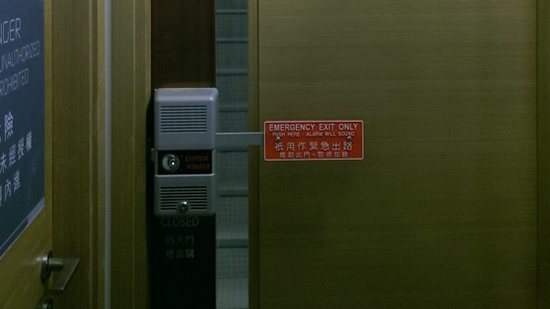 香港九龙贸易中心的绿色安全门,装有出口控制锁与中英文警示牌